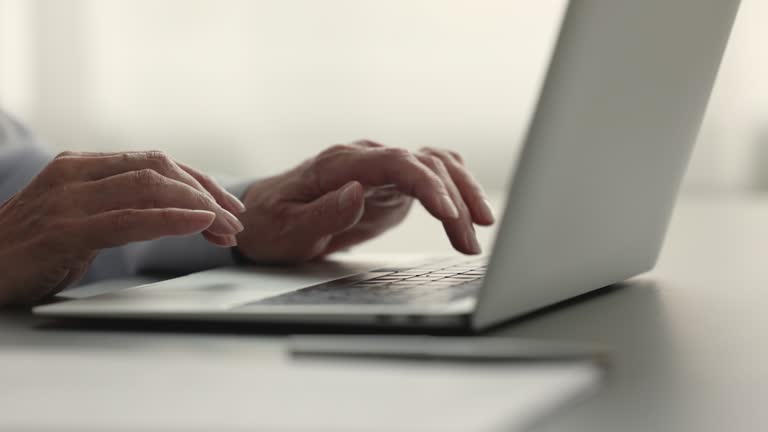 Businesswoman typing on laptop keyboard sit at office desk, close up