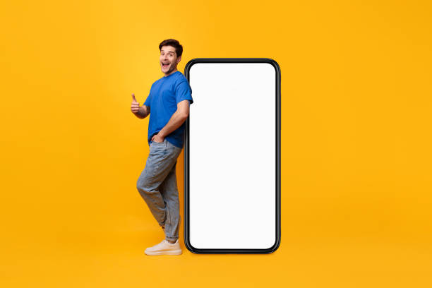 istock Man leaning on white blank smartphone screen showing thumbs up 1480800247
