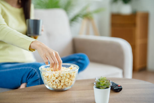 istock Asian woman Watching smart TV and using remote controller Hand holding television audio remote control at home with the remote control television 1480808988