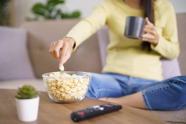 istock Asian woman Watching smart TV and using remote controller Hand holding television audio remote control at home with the remote control television 1480809008