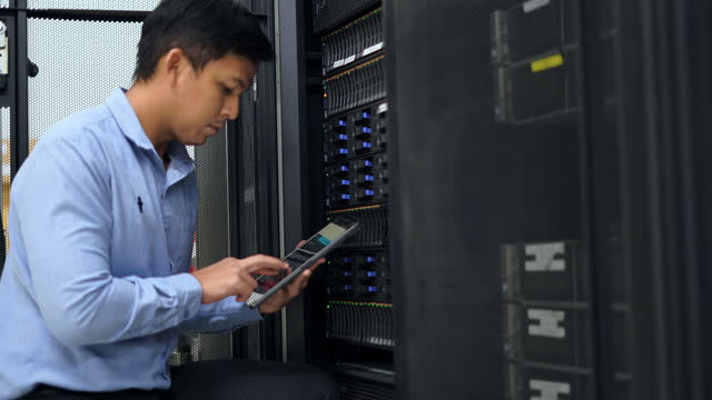 IT technical engineer checking server with application on tablet in Data center.