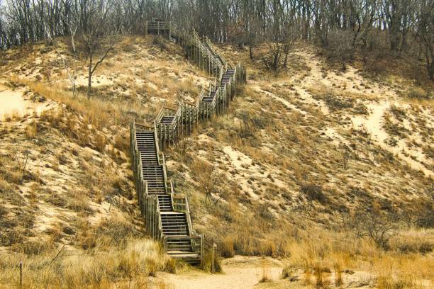 The view on an early Spring day of a wooden staircase climbing a sandy hill at Indiana Dunes National Park, near Chesterton, IN.