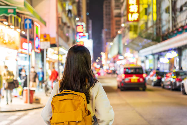 junge reisende, die auf dem nachtmarkt von mong kok in hongkong spazieren geht - hong kong billboard asia china stock-fotos und bilder