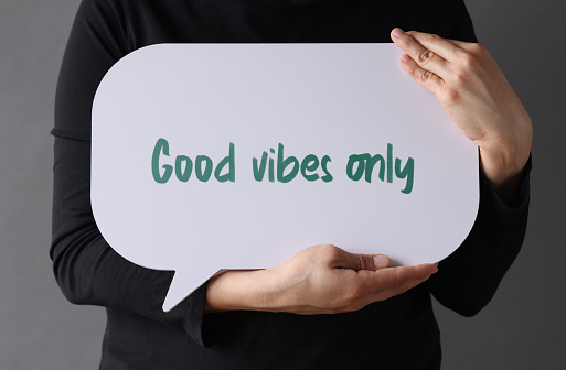 Woman holding speech bubble with Good Vibes Only text