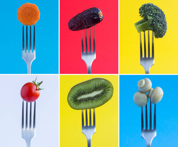 istock Collage. Vegetable and fruit  stabbed on a silver fork on the colored background. Close-up. 1480819665