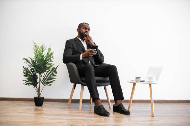 istock Thoughtful businessman sitting with smartphone at office 1480826219