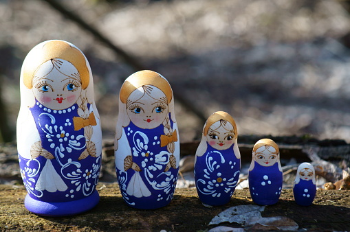 Matryoshka dolls decorated with patterns stand in a row. A cultural symbol. Human appearance.