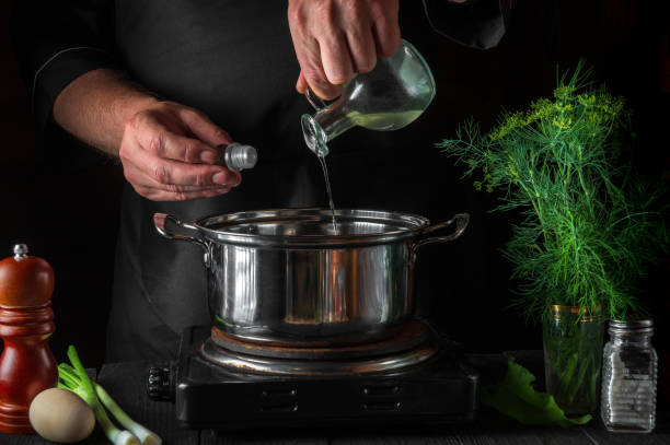 istock The cook adds oil to saucepan while making dumplings. Working environment on vintage kitchen table in restaurant. 1480829558