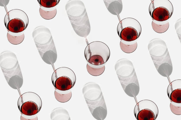 istock Minimal summer pattern with glasses of red wine, sunlight shadow on white background. Full and empty Wine glasses flat lay, alcohol drinks modern photo. Holidays, parties, events concept 1480839813