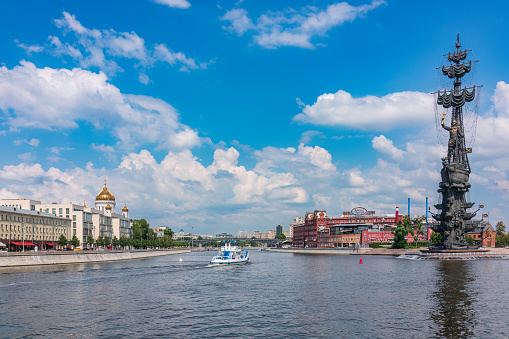Moscow, Russia - July 25, 2022: Moscow river and Peter the Great Statue. Sculpture by Zurab Tsereteli. The Cathedral of Christ the Savior and the Confectionery factory Red October in background.