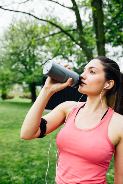 istock Sporty woman drinking water after running 1480843112