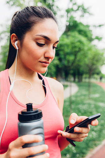 Sporty woman using smart phone after running