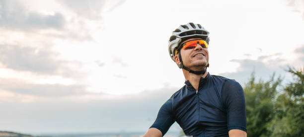 Panoramic portrait of a professional cyclist wearing helmet and protective sunglasses