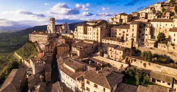 Impressive medieval Assisi town in Umbria over sunset. Italy.  aerial drone panoramic view. italian travel and best destinations