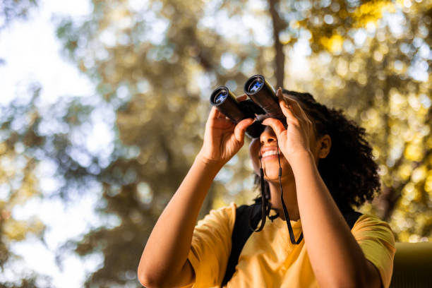 escursionista femminile che osserva attraverso il binocolo - osservare gli uccelli foto e immagini stock