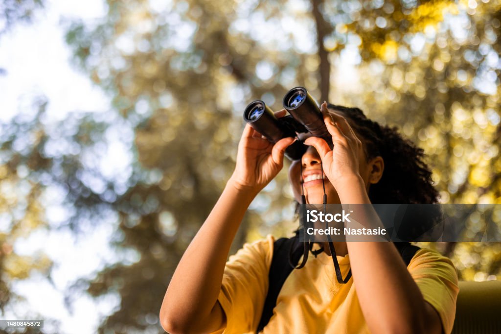 Female hiker watching through binoculars Hiker watching through binoculars Bird Watching Stock Photo