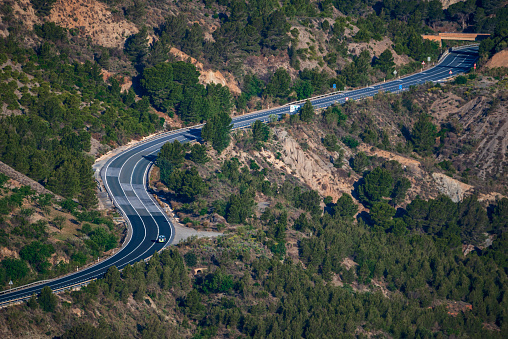 Police traffic control vehicle driving on a winding mountain road.