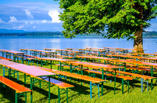 typical bavarian beergarden with wooden benches and tables - photo