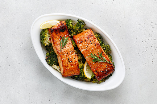 Salmon. Baked, roasted fish steaks, slices. Grilled salmon,trout fillet fish in marinade with broccoli in baking dish. Diet, meal, dinner. Top view, copy space.