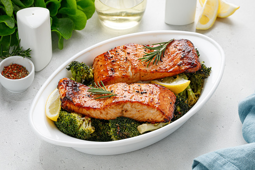 Salmon. Baked, roasted fish steaks, slices. Grilled salmon,trout fillet fish in marinade with broccoli in baking dish. Diet, meal, dinner.