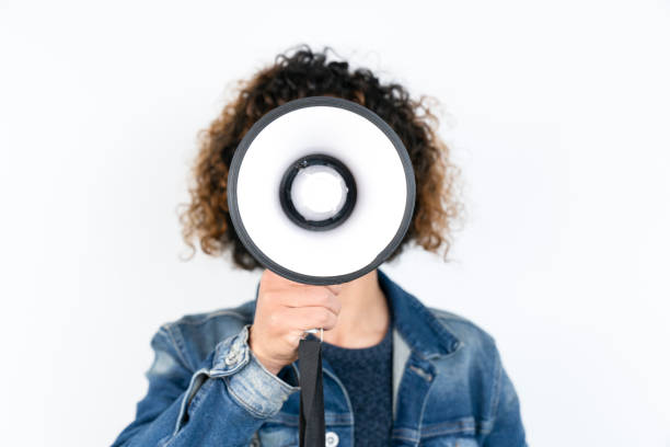 young man holding a megaphone while posing against a white background - american justice audio imagens e fotografias de stock