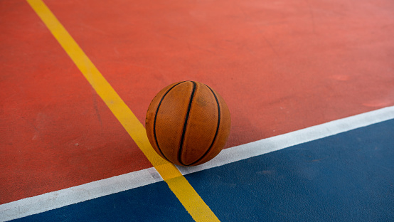 Basketball on the floor of a indoor court.