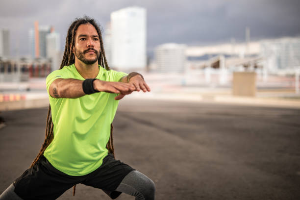 A young Latino Spaniard with dreadlocks is practicing outdoors in Barcelona, wearing a conspicuous flashy green T-shirt.