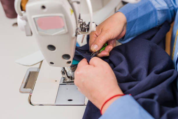 istock Atelier process needle detail. Unrecognizable woman hand on a sewing machine doing handmade fabric 1480864529