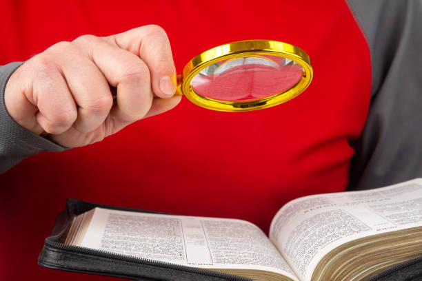 loupe pour lire un livre. bible ouverte. l’étude de la littérature. - magnification bible magnifying glass book photos et images de collection