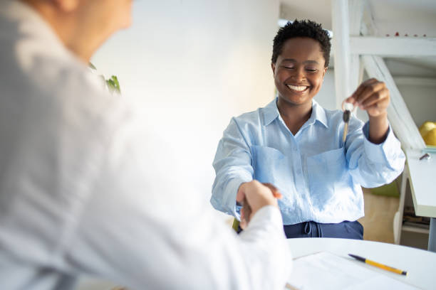 istock Real estate agent passing keys to his client 1480878657