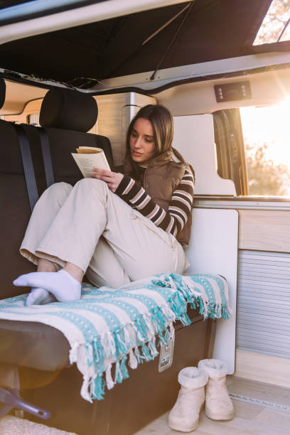istock woman reading book in a cozy camper van at sunset 1480878824
