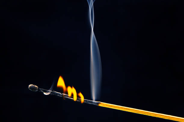 istock Flashed and burning wooden match on a dark background close-up. Bright fire and smoke from a burning tree. 1480881990