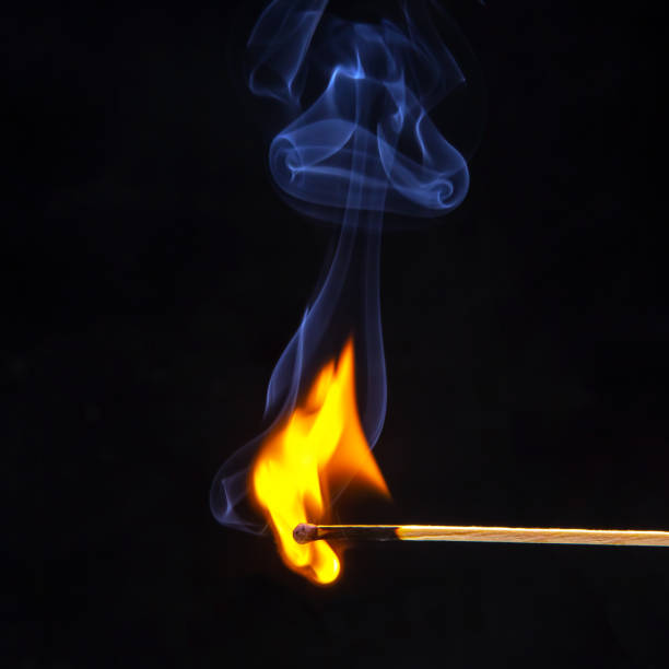 istock Flashed and burning wooden match on a dark background close-up. Bright fire and smoke from a burning tree. 1480882206