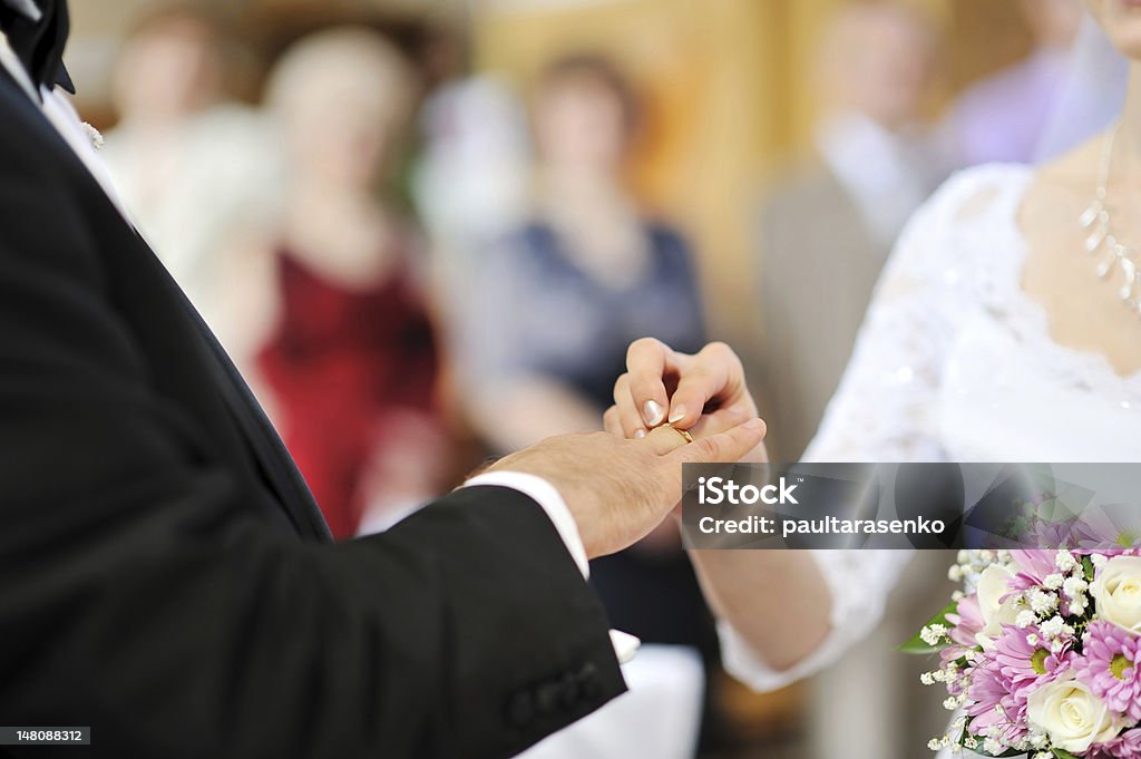 Sposa mette un anello nuziale sul dito di sposi - Foto stock royalty-free di Cerimonia di nozze