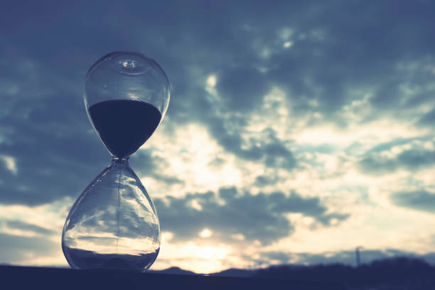 istock Sunset and glass hourglass silhouette 1480887157