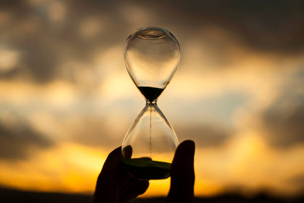 istock Sunset and glass hourglass silhouette 1480887158