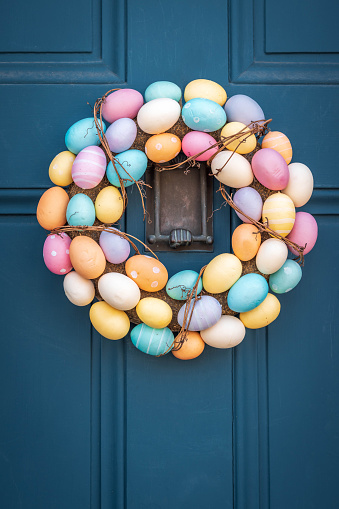 A wreath of Easter eggs hangs on a classic New England door