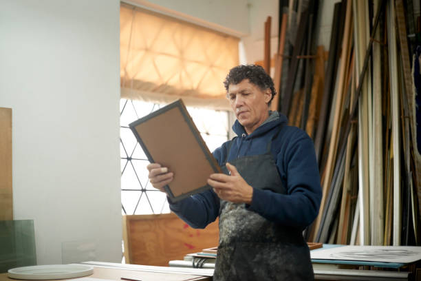 istock Frame, woodwork man and carpenter in workshop designing frames for photos or pictures. Creative, art and diy male, carpentry designer or lumber worker in small business for wood work holding product. 1480894641