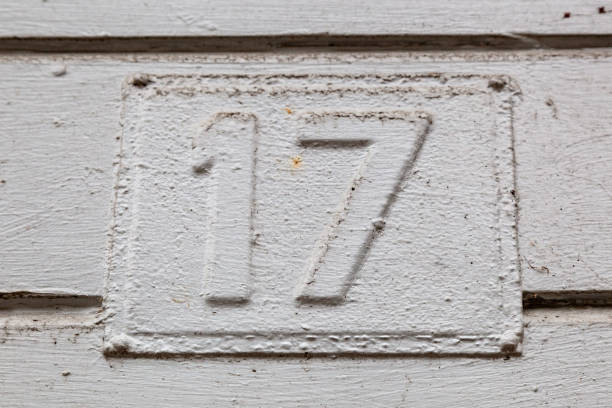 istock 17 number plaque on timber with white paint peeling show old age and vintage. 1480895555