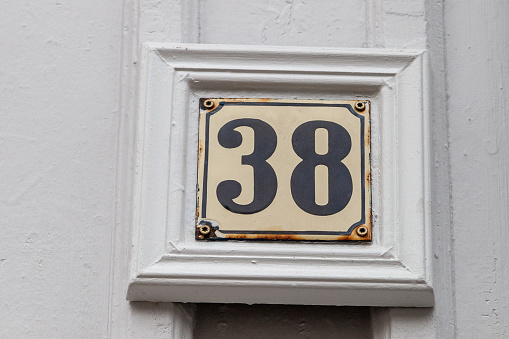 38 number plaque with rust in timber frame on swedish shiplap boards showing old age and vintage. House or business number best for online recaptcha and verification processes. Pick a number bingo games, brochures. European style