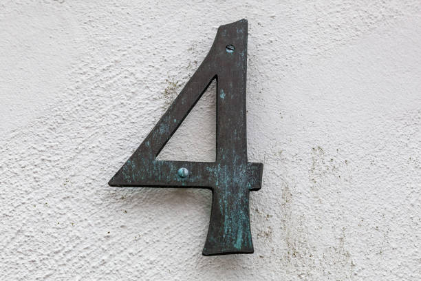 istock 4 decorative number plaques on white rendered cement house facade. 1480895569