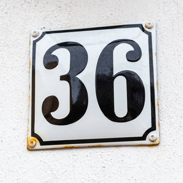 istock 36 metal decorative number plaque on white rendered cement house facade. 1480895570