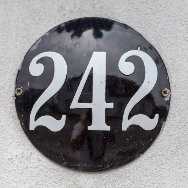 istock 242 metal decorative number plaque on white rendered cement house facade. 1480895571
