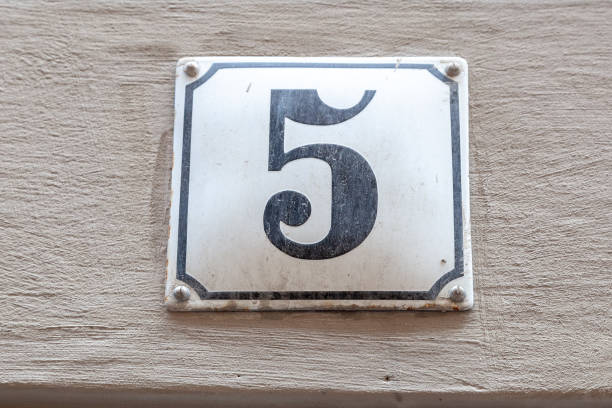 istock 5 metal decorative number plaque on white rendered cement house facade. 1480895572
