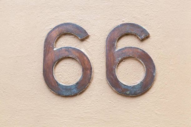 istock 66 numerals in copper fixed against a cream painted rendered brick wall. 1480895586