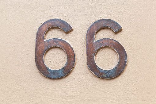 66 numerals in copper fixed against a cream painted rendered brick wall. Business address, good for online security recaptcha and verification processes. Pick a number bingo games, brochures. European Style