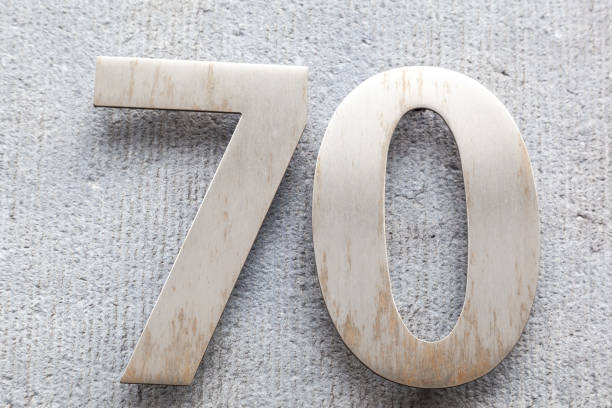 istock 70 numerals in brushed steel fixed against a grey cement block. 1480895593