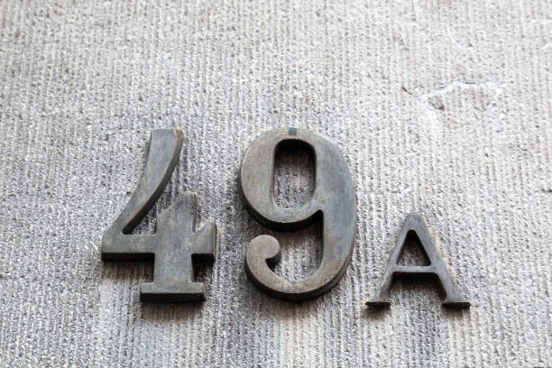 istock 49a numerals in cast steel fixed against a grey cement block. 1480895595