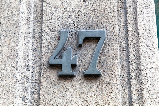 47 numerals in cast steel fixed against a grey cement block. Business address, good for online security recaptcha and verification processes. Pick a number bingo games, brochures. European Style