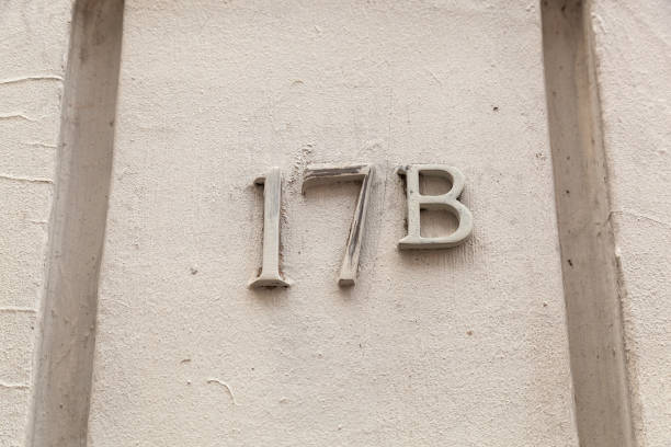 17b numerals in cast steel fixed against a cream painted cement block.